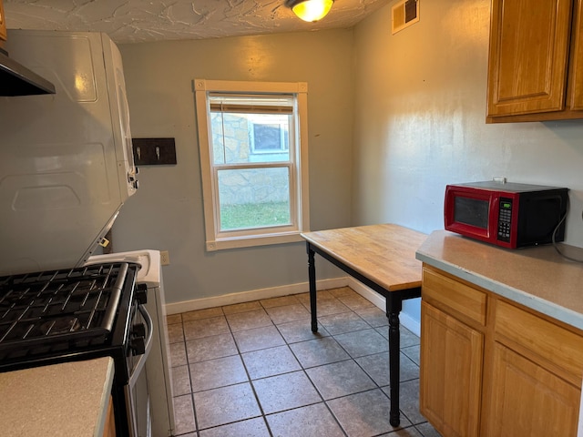 kitchen with gas range and light tile patterned flooring