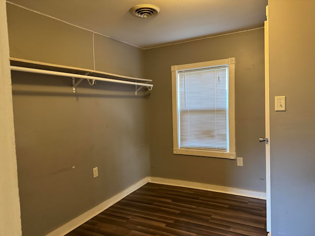 spacious closet with dark hardwood / wood-style flooring