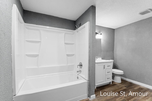 full bathroom with hardwood / wood-style floors, shower / bath combination, a textured ceiling, toilet, and vanity