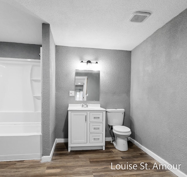full bathroom featuring hardwood / wood-style floors, vanity, and a textured ceiling
