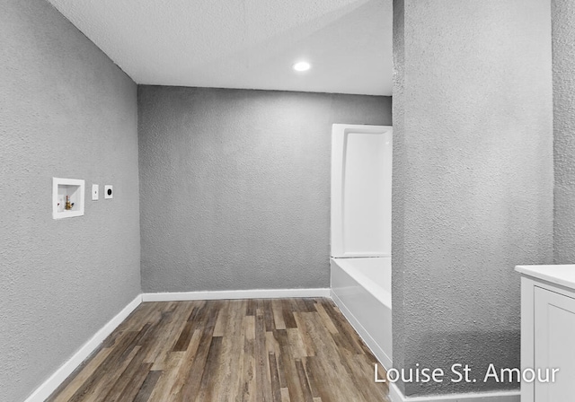 interior space with electric dryer hookup, hookup for a washing machine, dark wood-type flooring, and a textured ceiling