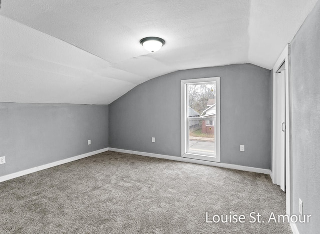 bonus room featuring carpet, a textured ceiling, and vaulted ceiling