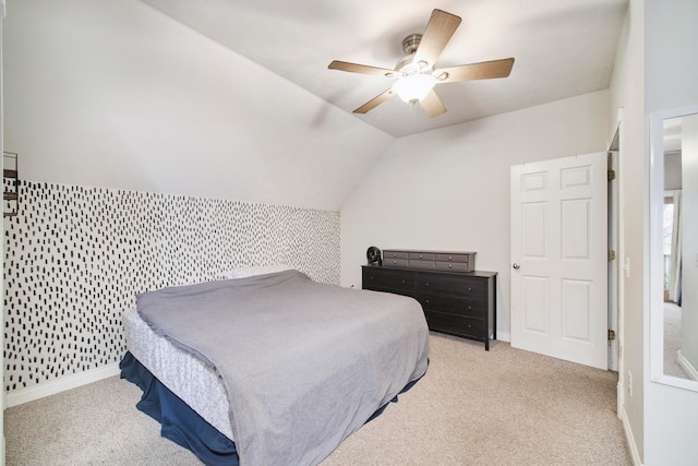 bedroom with ceiling fan, light carpet, and vaulted ceiling