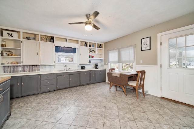 kitchen featuring ceiling fan, sink, built in features, a textured ceiling, and gray cabinets