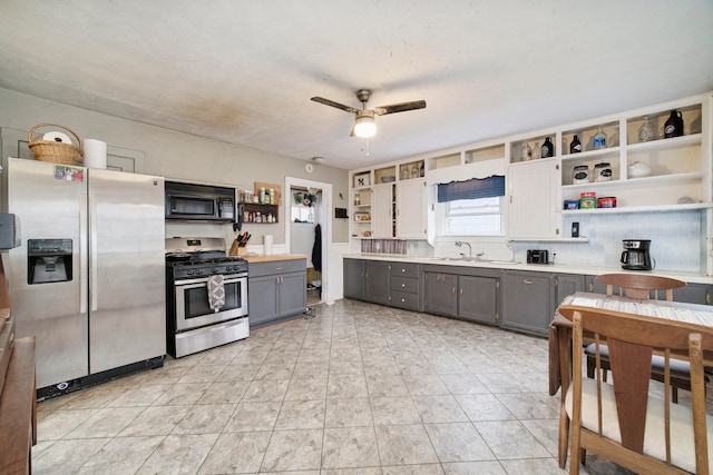 kitchen featuring ceiling fan, gray cabinets, appliances with stainless steel finishes, and tasteful backsplash