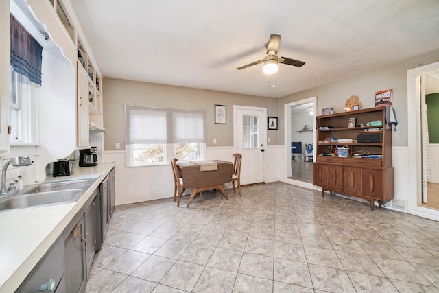 kitchen featuring ceiling fan, sink, and light tile patterned flooring