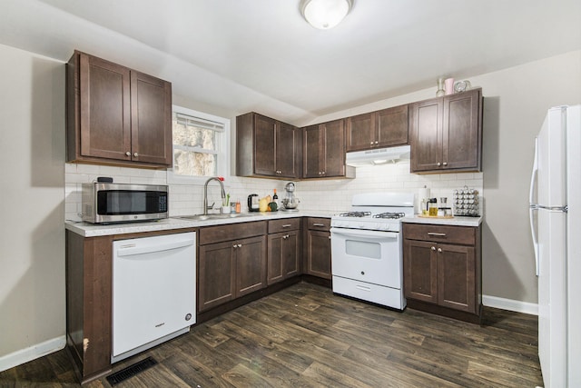 kitchen with dark brown cabinets, dark hardwood / wood-style flooring, white appliances, and sink