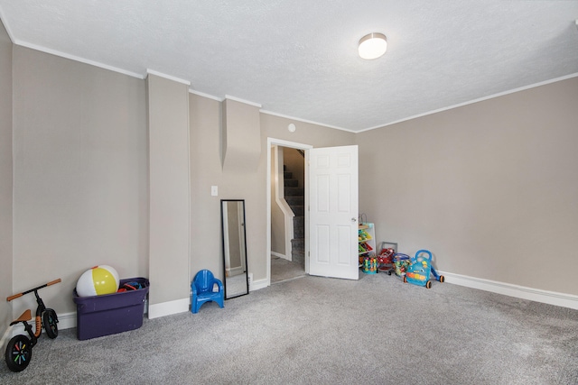 game room with carpet flooring, a textured ceiling, and crown molding