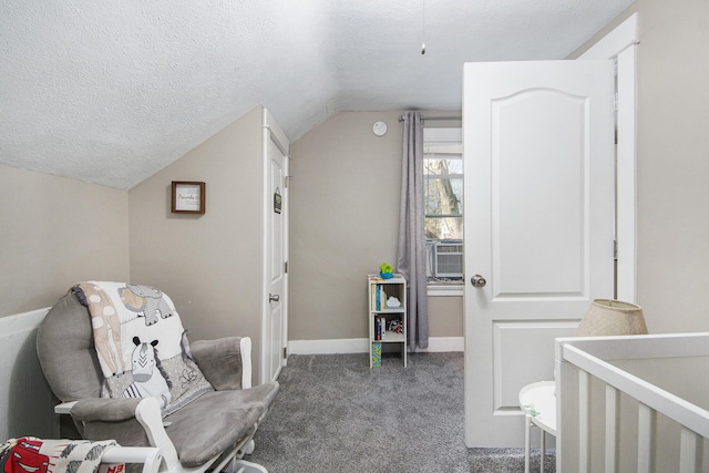 carpeted bedroom featuring a crib, a textured ceiling, and lofted ceiling