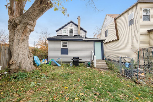 rear view of property with a lawn