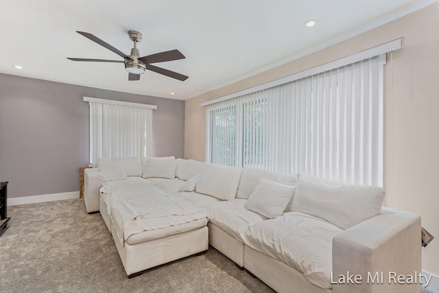 carpeted living room with ceiling fan