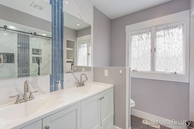 bathroom with tile patterned floors, vanity, toilet, and walk in shower