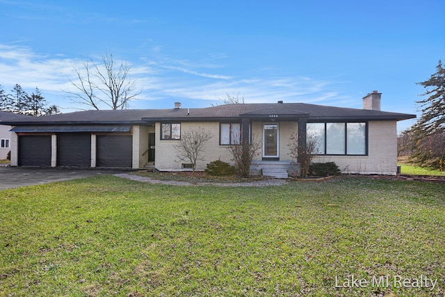 single story home featuring a front lawn and a garage