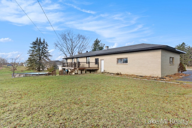 back of house with a lawn and a deck