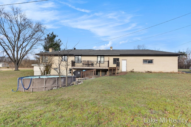 back of property with a swimming pool side deck and a yard