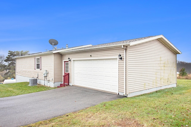 garage featuring central AC and a lawn