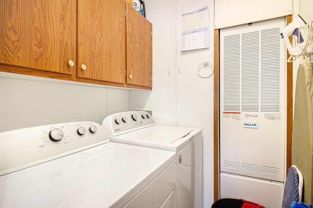 washroom featuring washing machine and clothes dryer and cabinets