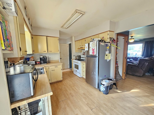 kitchen featuring stainless steel fridge, light brown cabinetry, gas range gas stove, ceiling fan, and light hardwood / wood-style flooring