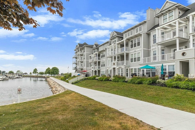 view of community featuring a lawn and a water view