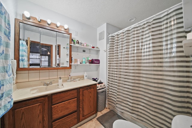 bathroom with a shower with shower curtain, vanity, toilet, and a textured ceiling