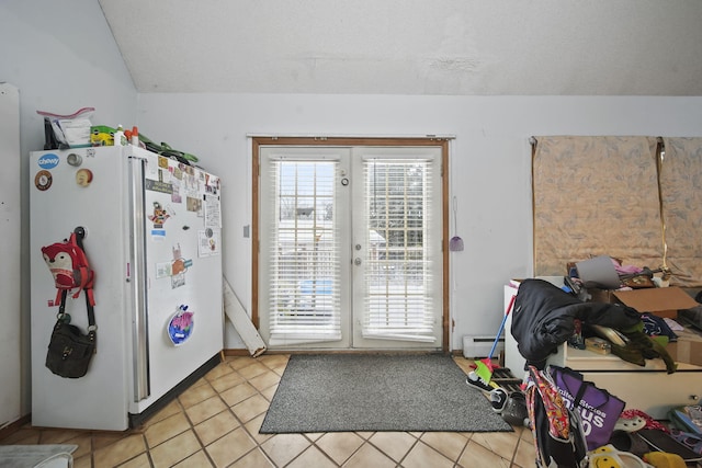 entryway featuring a baseboard heating unit, french doors, and vaulted ceiling