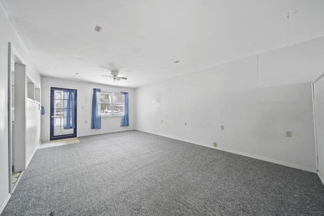 carpeted spare room featuring ceiling fan