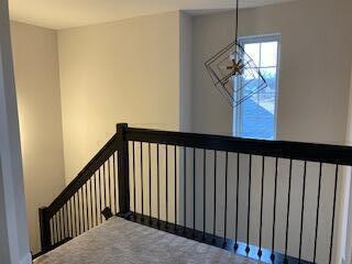 staircase with carpet floors and an inviting chandelier