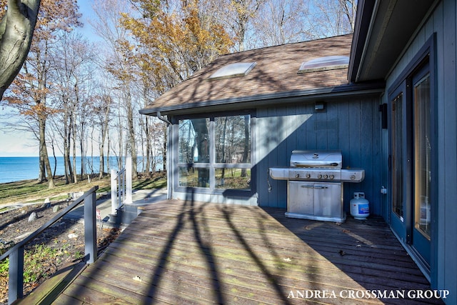 deck featuring a water view and a grill