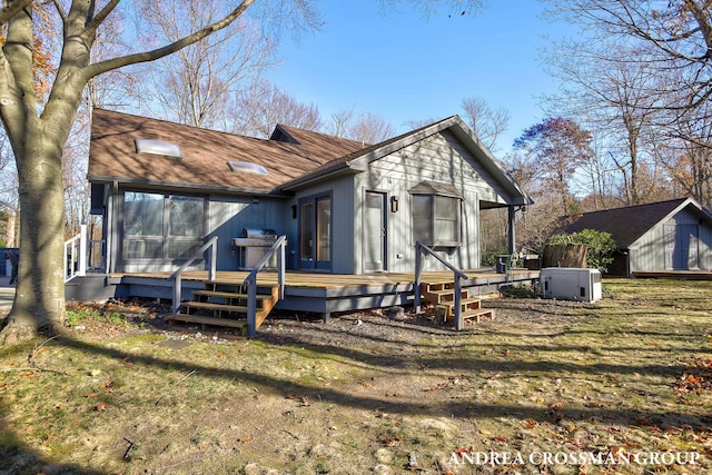 back of property featuring a deck and a yard