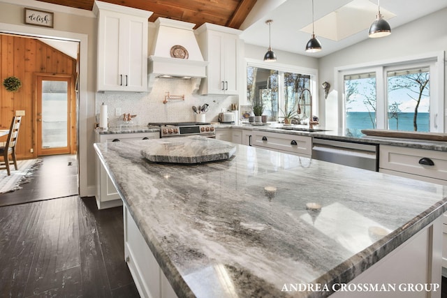 kitchen with white cabinetry, plenty of natural light, a water view, and appliances with stainless steel finishes