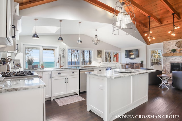 kitchen with a wealth of natural light, sink, white cabinets, and decorative light fixtures