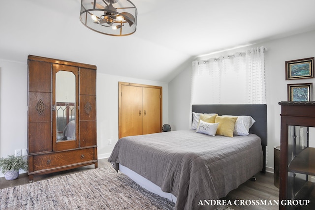 bedroom with a closet, dark hardwood / wood-style flooring, and vaulted ceiling