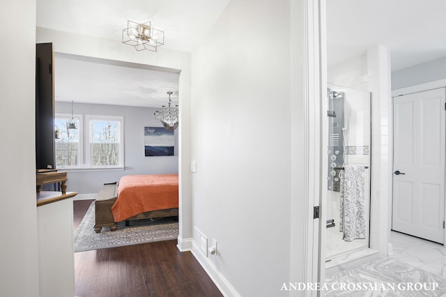 hallway featuring hardwood / wood-style flooring and a notable chandelier