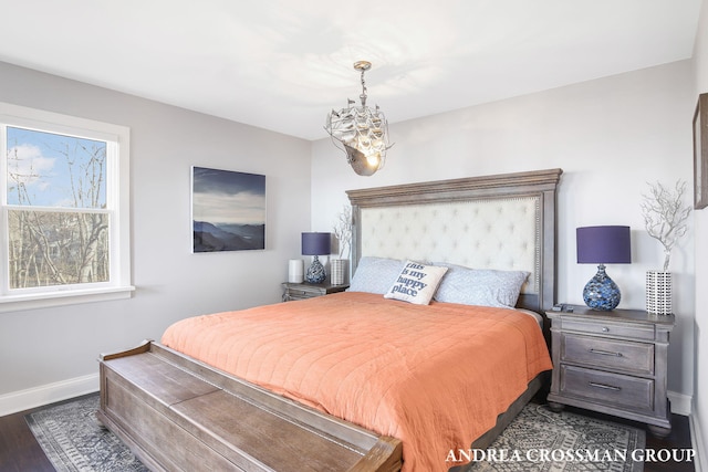 bedroom with dark hardwood / wood-style flooring and a chandelier