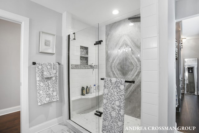 bathroom with hardwood / wood-style flooring and a shower with shower door