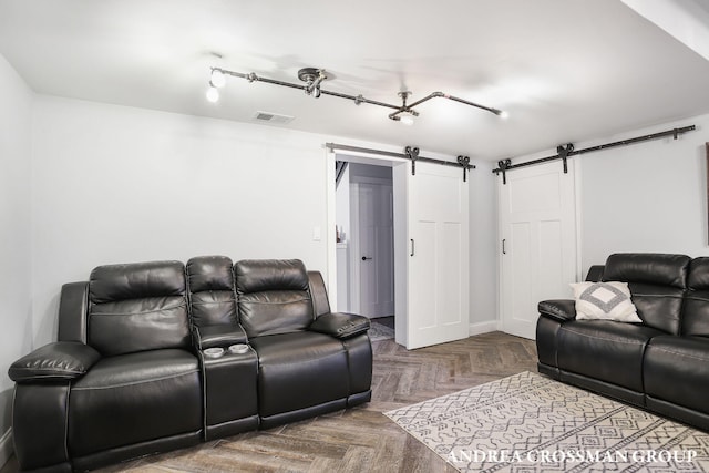 cinema room featuring a barn door and parquet floors