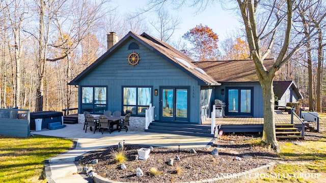 view of front of home with a hot tub, a patio area, and a wooden deck