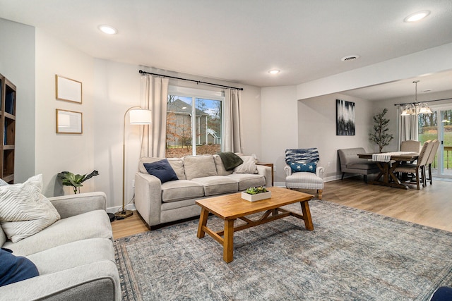 living room with hardwood / wood-style floors and a notable chandelier