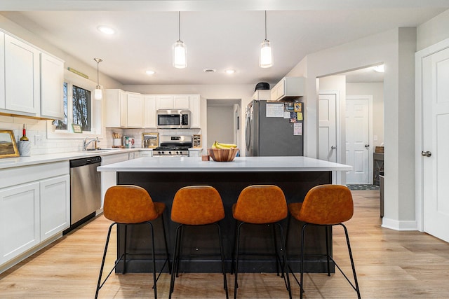 kitchen featuring white cabinets, stainless steel appliances, and a kitchen island