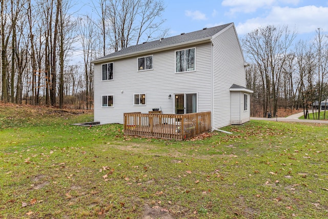 rear view of house with a lawn and a wooden deck