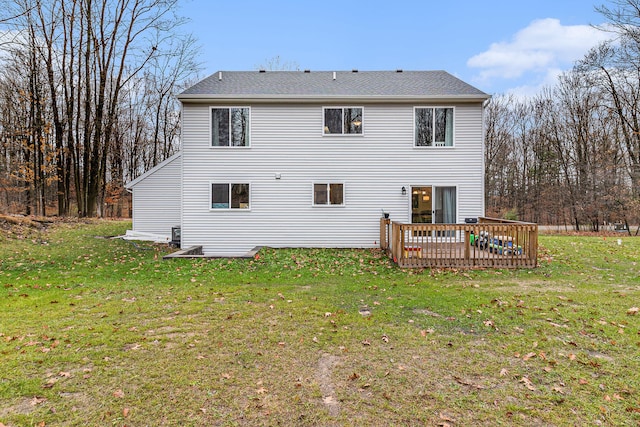 rear view of property featuring a yard and a wooden deck