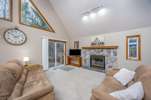 carpeted living room with a wealth of natural light, a fireplace, and high vaulted ceiling