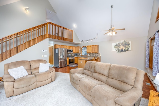 living room featuring ceiling fan, light wood-type flooring, and high vaulted ceiling