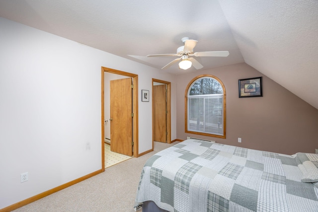 carpeted bedroom with ceiling fan, a textured ceiling, and vaulted ceiling