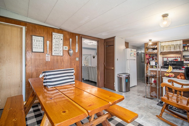 dining space with wooden walls and lofted ceiling