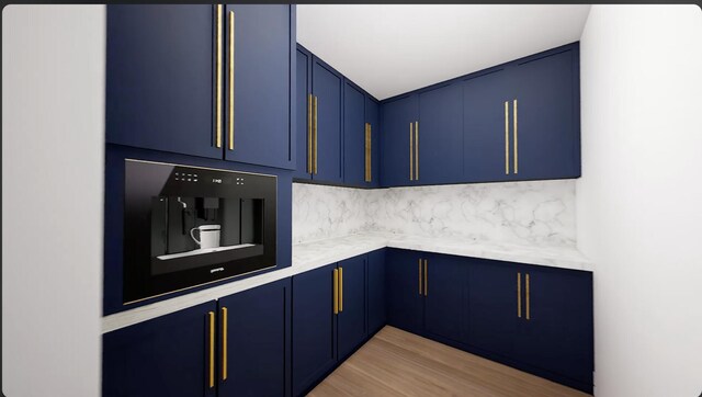 kitchen with blue cabinetry, tasteful backsplash, and light hardwood / wood-style floors