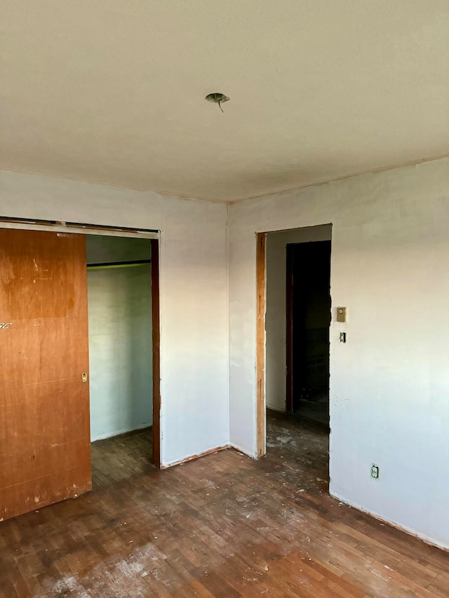 unfurnished bedroom featuring dark hardwood / wood-style flooring and a closet