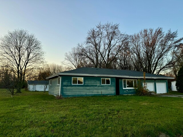 single story home featuring a yard and a garage