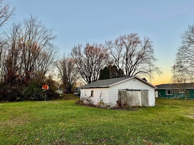 yard at dusk featuring a storage unit