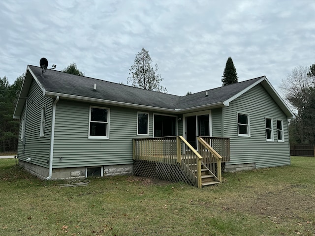 back of house featuring a deck and a lawn